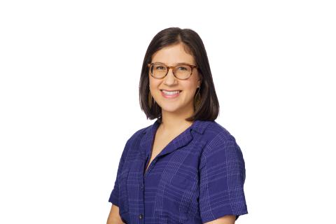 woman with glasses in a blue top smiling