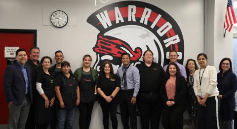 staff in front of the school logo